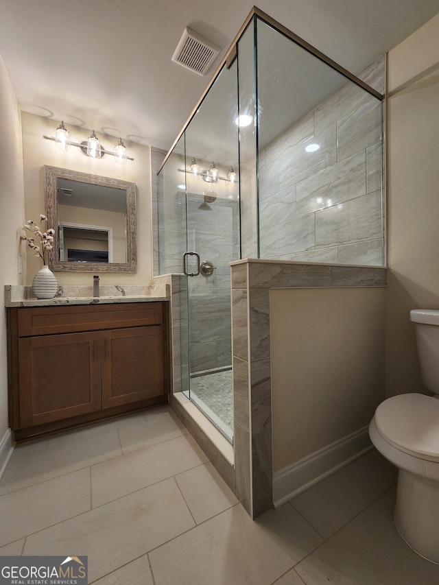 bathroom featuring tile patterned flooring, vanity, toilet, and walk in shower