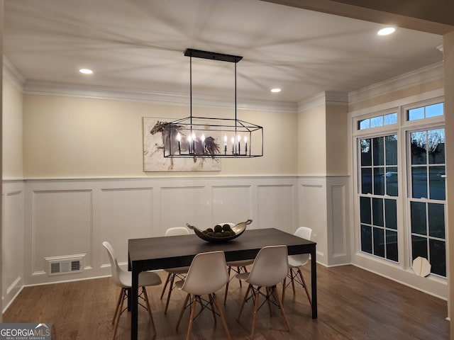 dining space featuring a chandelier, crown molding, and dark wood-type flooring