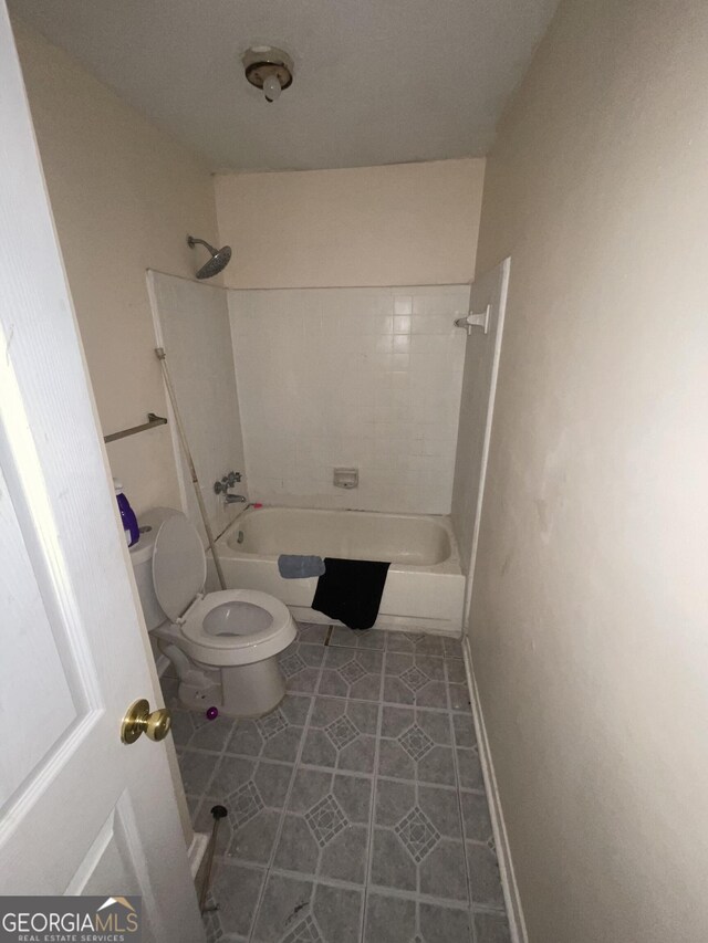 bathroom featuring tile patterned floors, toilet, and bathing tub / shower combination