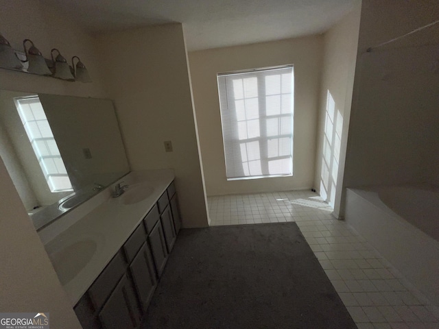 bathroom featuring tile patterned flooring, vanity, and a tub to relax in