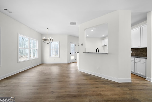 interior space with dark hardwood / wood-style floors, a notable chandelier, and sink