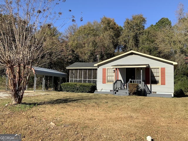 manufactured / mobile home with a front yard, a carport, and a sunroom