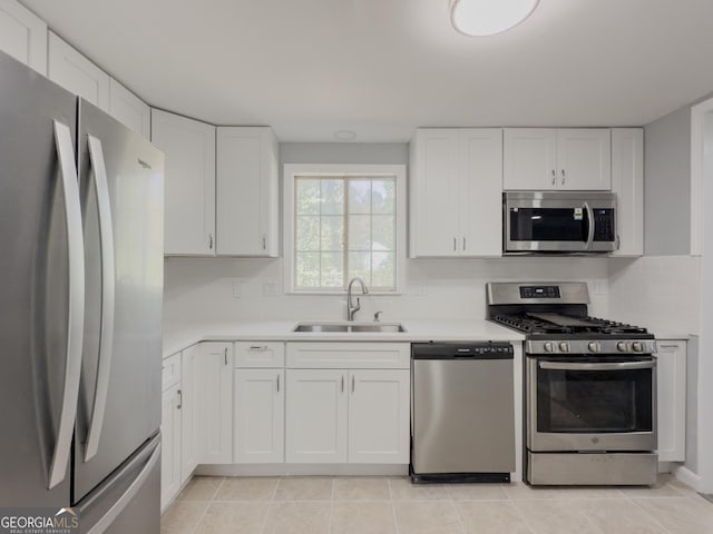 kitchen featuring appliances with stainless steel finishes, white cabinetry, and sink