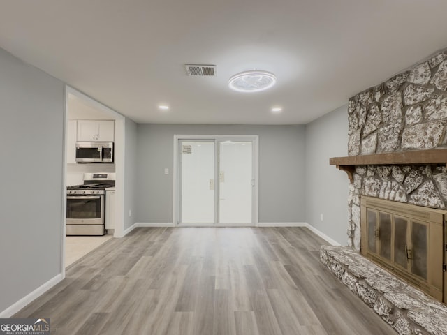 unfurnished living room featuring a fireplace and light wood-type flooring