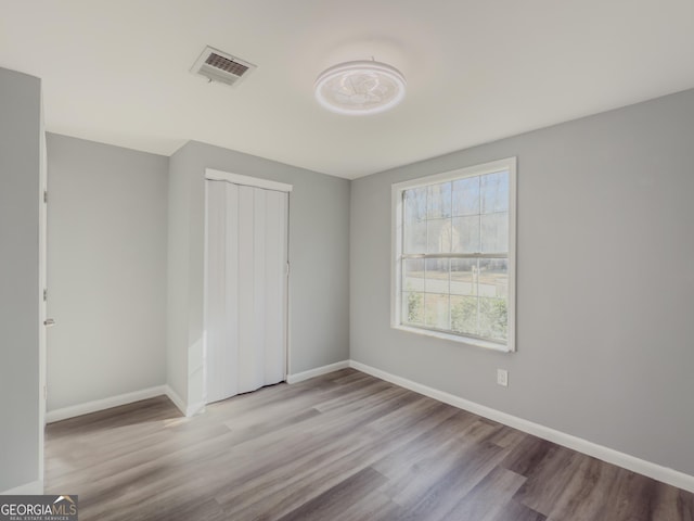 unfurnished bedroom with a closet and light wood-type flooring