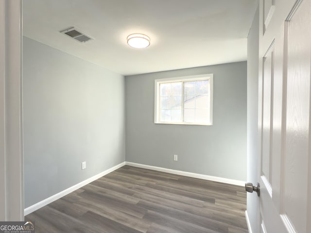 unfurnished room with dark wood-type flooring