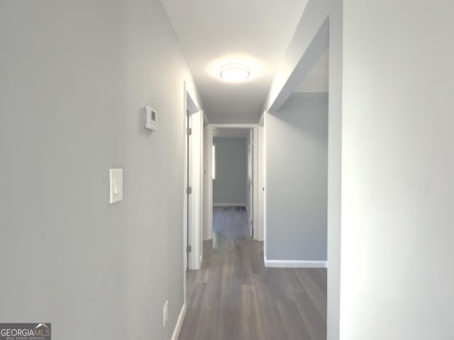 corridor with dark hardwood / wood-style flooring