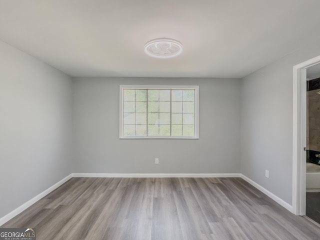 unfurnished room with light wood-type flooring