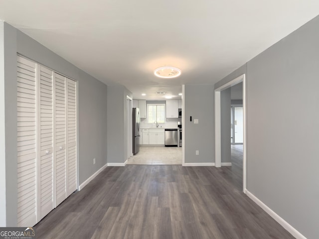 corridor with hardwood / wood-style floors and sink