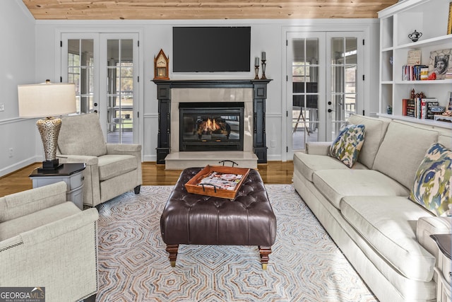 living room with french doors, light hardwood / wood-style flooring, built in shelves, and wood ceiling