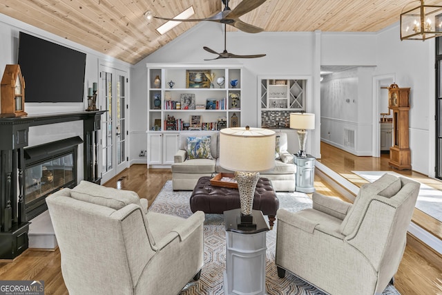 living room with ceiling fan with notable chandelier, light hardwood / wood-style floors, and wood ceiling