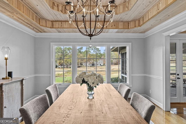 dining room with hardwood / wood-style floors, a raised ceiling, crown molding, and an inviting chandelier