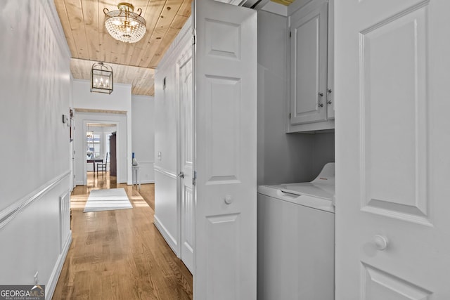 clothes washing area featuring cabinets, light wood-type flooring, washer / dryer, wood ceiling, and a chandelier