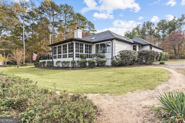 view of property exterior featuring a lawn and a sunroom