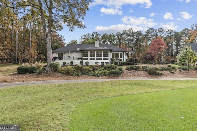 view of front of house featuring a front lawn and a sunroom