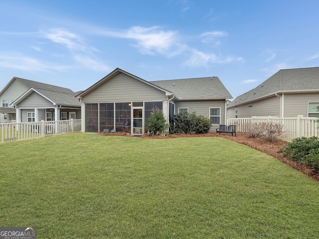 back of property with a sunroom and a yard