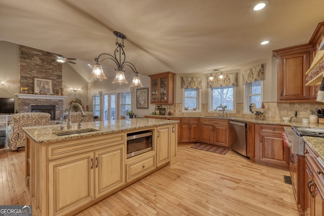 kitchen with sink, decorative backsplash, a kitchen island with sink, and appliances with stainless steel finishes