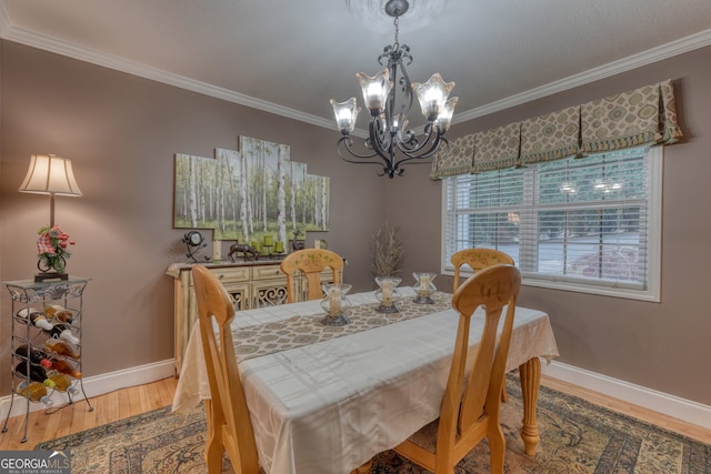 dining space featuring ornamental molding, hardwood / wood-style flooring, and a notable chandelier