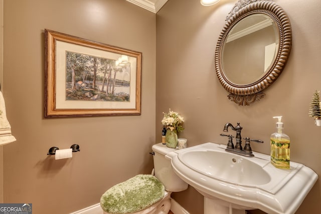 bathroom featuring sink, toilet, and ornamental molding