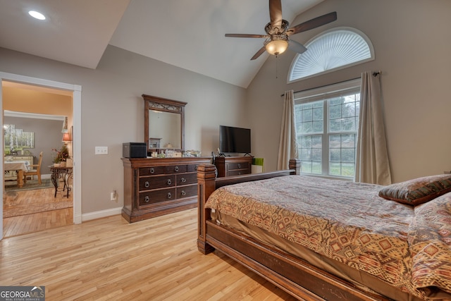 bedroom with high vaulted ceiling, ceiling fan, and light hardwood / wood-style flooring