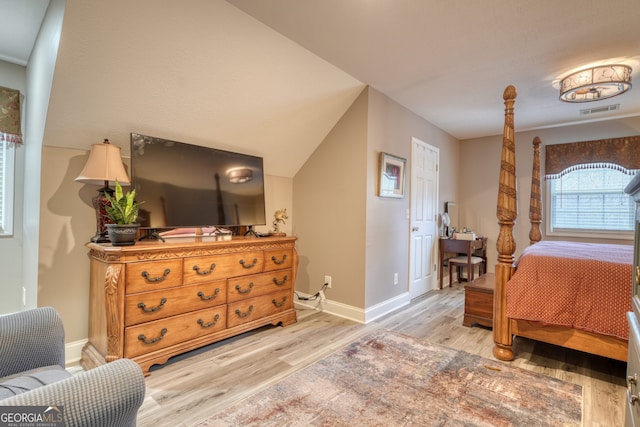 bedroom with lofted ceiling and light hardwood / wood-style floors