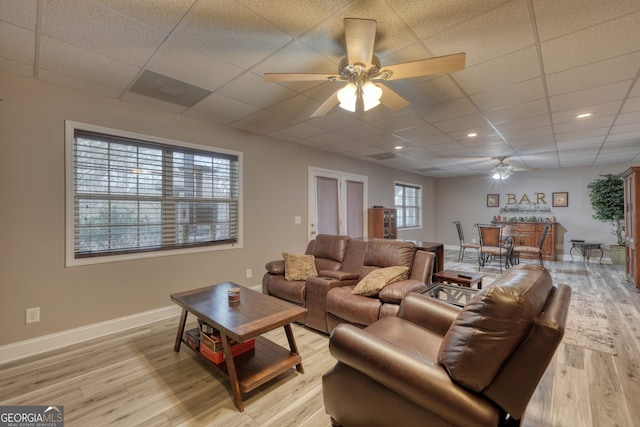 living room featuring light hardwood / wood-style floors, ceiling fan, and a paneled ceiling