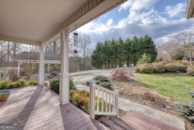 deck with a porch and a lawn