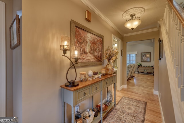 hallway with light wood-type flooring, crown molding, and a textured ceiling