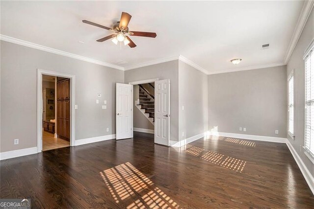 empty room with a healthy amount of sunlight, dark hardwood / wood-style flooring, and crown molding