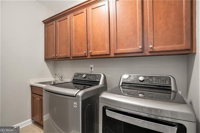 laundry room featuring washer and dryer, light tile patterned flooring, cabinets, and sink