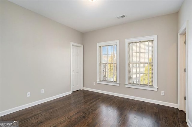 spare room with dark wood-type flooring