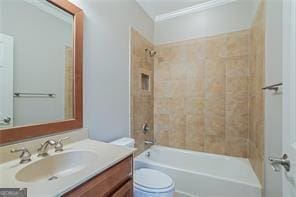 full bathroom featuring vanity, toilet, ornamental molding, and tiled shower / bath