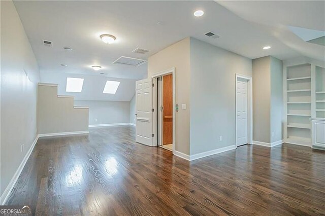 bonus room with lofted ceiling, built in features, and dark wood-type flooring