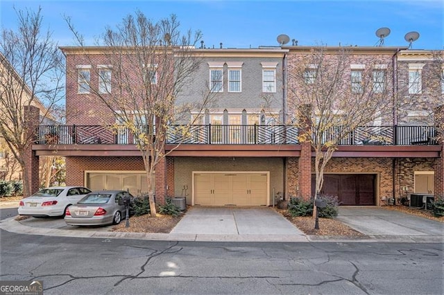 townhome / multi-family property with central AC unit and a garage