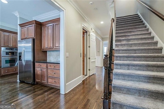 stairs featuring hardwood / wood-style floors and ornamental molding