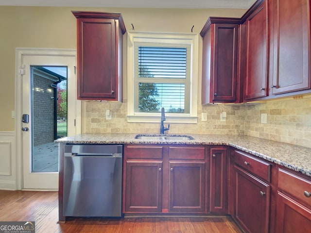 kitchen featuring dishwasher, dark wood-type flooring, sink, decorative backsplash, and light stone countertops