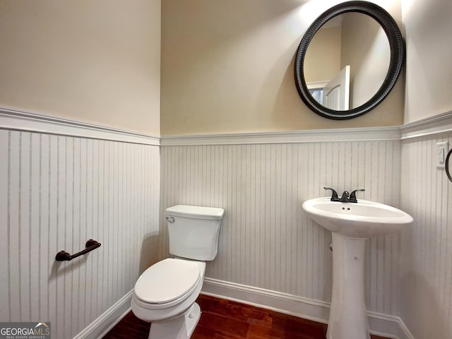 bathroom with toilet, wood-type flooring, and sink