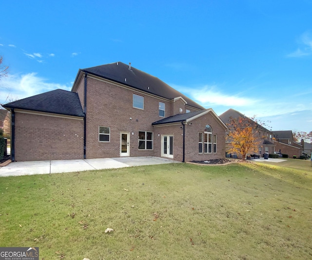 rear view of property with a yard and a patio