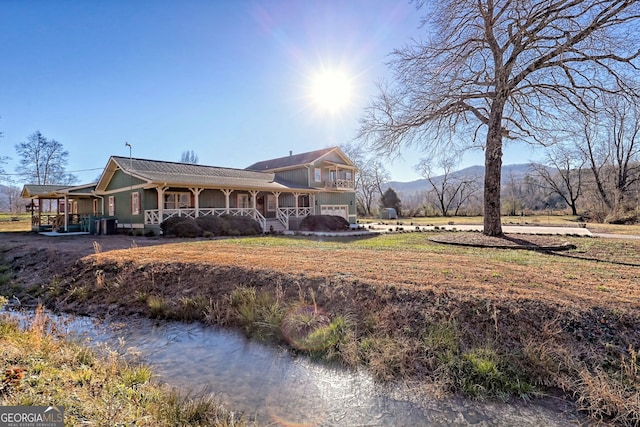 rear view of property with a mountain view and a porch