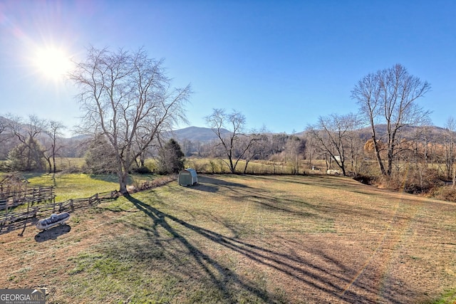 view of yard with a mountain view, a rural view, and a storage unit