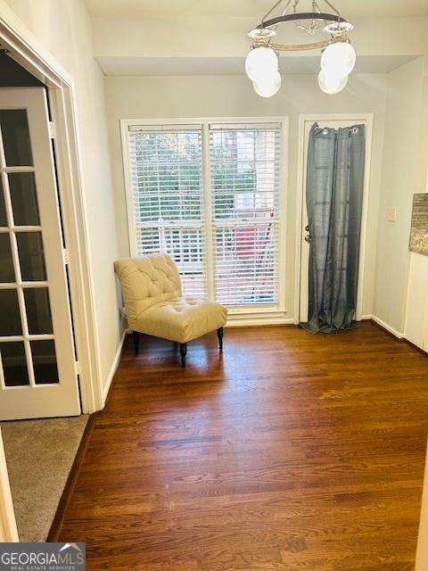 unfurnished room with dark hardwood / wood-style floors and an inviting chandelier