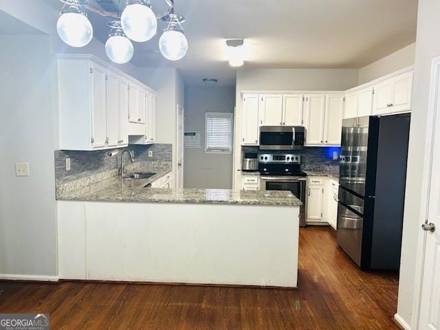 kitchen with stainless steel appliances, sink, pendant lighting, dark hardwood / wood-style floors, and white cabinetry