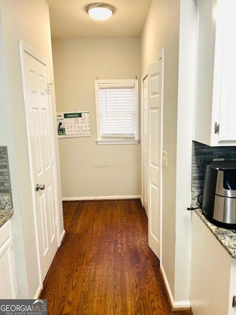 hallway with dark hardwood / wood-style flooring