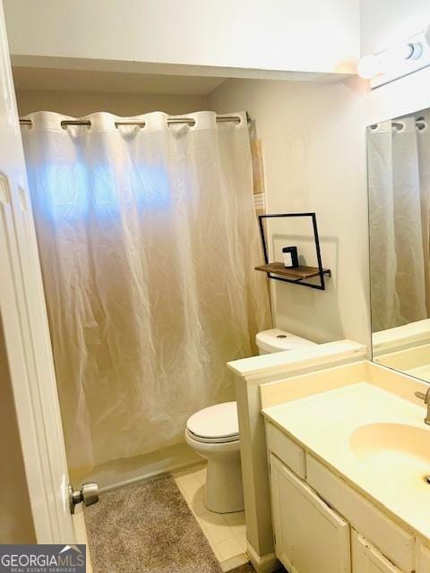 bathroom with curtained shower, tile patterned flooring, vanity, and toilet