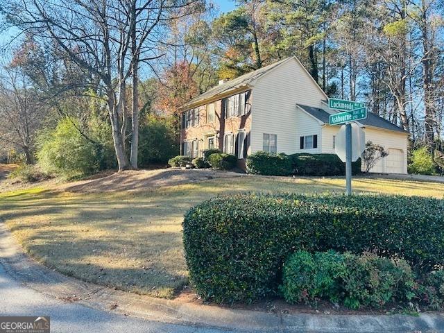 view of side of property featuring a yard and a garage