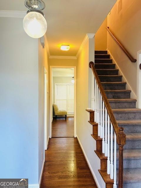 stairs featuring hardwood / wood-style flooring and crown molding