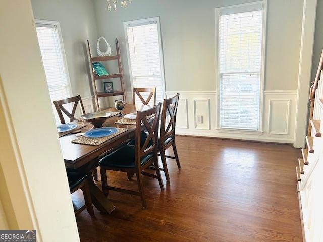 dining area with dark wood-type flooring and a notable chandelier