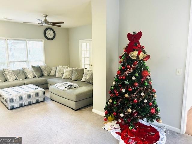 carpeted living room featuring ceiling fan