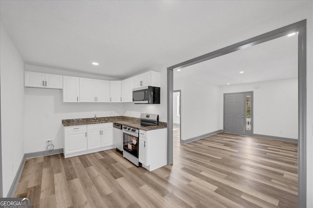 kitchen featuring white cabinets, sink, light hardwood / wood-style flooring, dark stone countertops, and appliances with stainless steel finishes