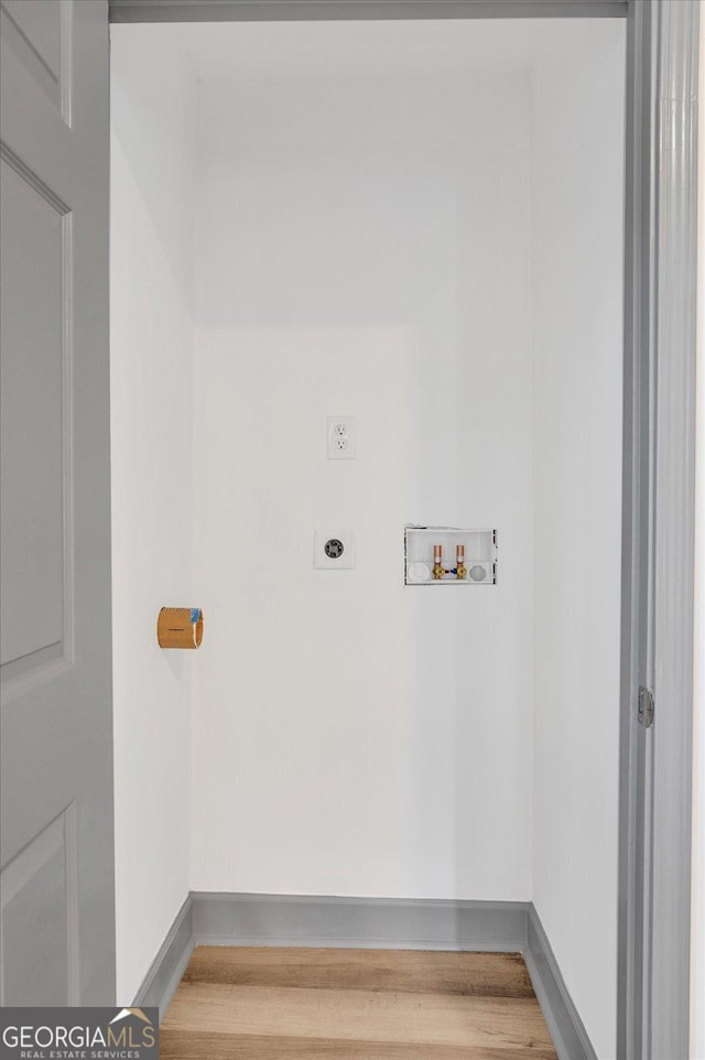 clothes washing area with hookup for a washing machine, hardwood / wood-style flooring, and electric dryer hookup